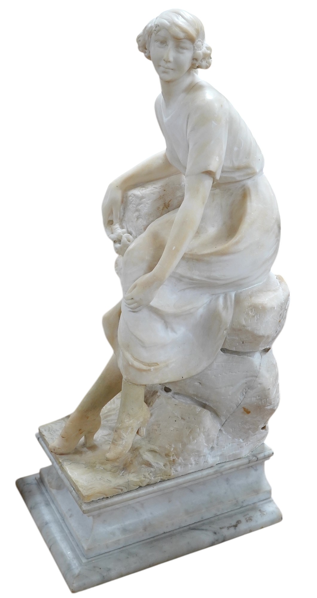 A French 1920’s-30’s alabaster sculpture of a lady seated on a stone wall, sculpture mounted on a marble stand, 63cm high. Condition - crack to alabaster at the front and discoloured restoration